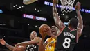 Pemain Los Angeles Lakers, Kobe Bryant berusaha memasukan bola dari kawalan dua pemain Toronto Raptors DeMar DeRozan dan Bismack Biyombo selama pertandingan NBA di Los Angeles Pada 20 November 2015. (AP Photo/Mark J. Terrill)