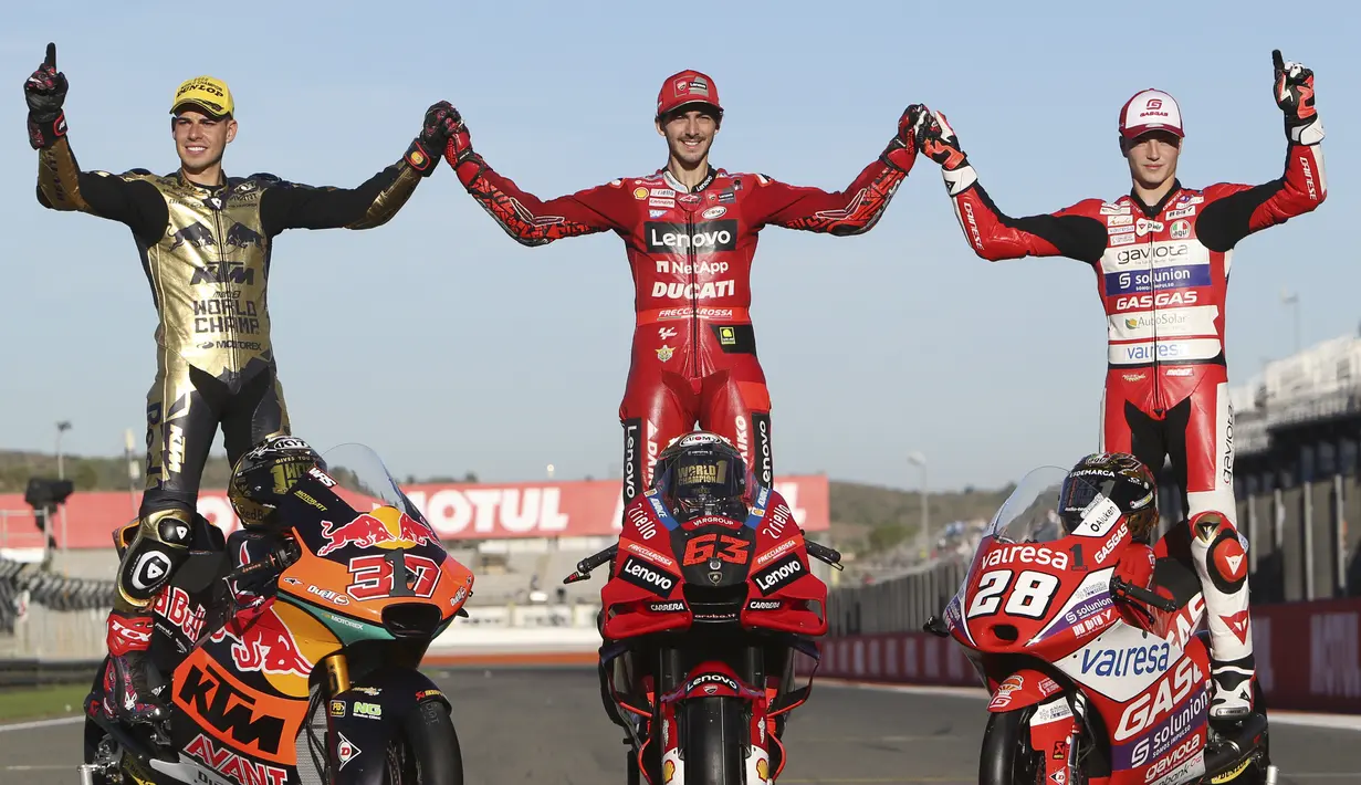 Juara Dunia Moto GP Pembalap Ducati Francesco Bagnaia (tengah) merayakan dengan Juara Dunia Moto2 Pembalap Red Bull KTM Ajo, Augusto Fernandez (kiri) dan Juara Dunia Moto3 pembalap GASGAS Aspar Team, Izan Guevara pada akhir balapan MotoGP Valencia 2022 di sirkuit Ricardo Tormo, Valencia, Minggu (6/11/2022). (AP Photo/Alberto Saiz)