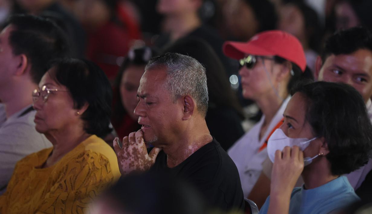 Suasana khidmat dan seringkali mengharukan, diiringi narasi reflektif serta lagu rohani. Tampak dalam foto, umat Katolik saat menyaksikan drama visualisasi prosesi penyaliban Yesus saat peringatan Jumat Agung di Gereja Katedral, Jakarta, Jumat (3/4/2026). (Kapanlagi.com/Budy Santoso)