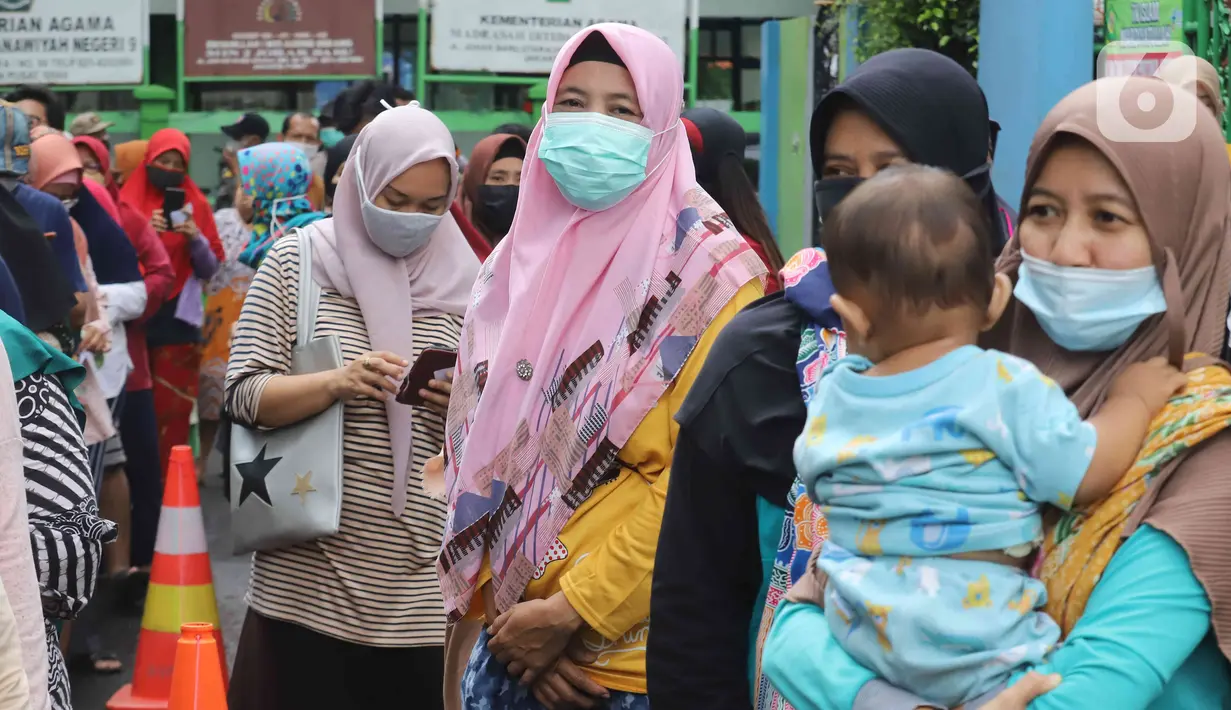 Warga mengantre minyak goreng murah di Kantor Kecamatan Johar Baru, Jakarta, Senin (17/1/2022). Sudin Perindustrian, Perdagangan, Koperasi, Usaha Kecil dan Menengah (PPKUKM) Jakarta Pusat menggelar Operasi Pasar minyak goreng murah dengan harga Rp 14.000 per liter. (Liputan6.com/Herman Zakahria)