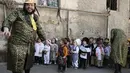 Sejumlah pria mengatur anak-anak untuk bersipa mengikuti perayaan purim di Yerusalem (8/3). Purim merupakan hari raya atau pesta Yahudi untuk memperingati pembebasan kaum Yahudi dari kekaisaran Persia. (AFP/Menahem Kahana)