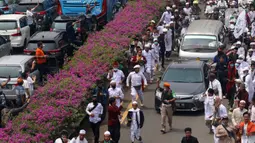 Ratusan massa berkonvoi mengawal Rizieq Shihab usai tiba di Bandara Soekarno-Hatta, Tangerang, Banten, Selasa (10/11/2020). Konvoi tersebut dilakukan untuk mengawal perjalan Rizieq Shihab menuju kediamannya di Petamburan, Jakarta. (Liputan6.com/Angga Yuniar)