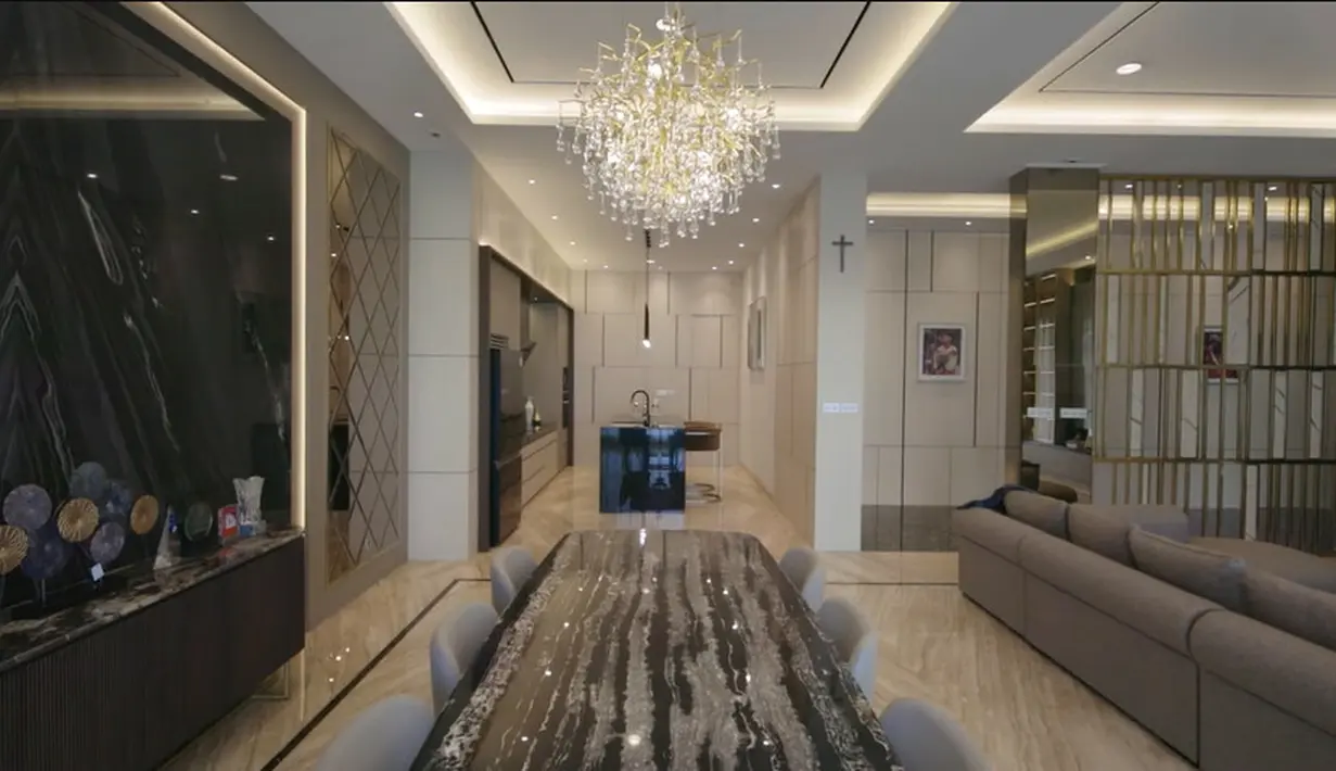 <p>Ruang keluarga dengan ruang makan mengusung konsep one space. Meja makan mewah dan di atasnya mengantung lampu kristal. "Ruang makan ruang keluarga interiornya sangat bagus sekali sesuai keingiannya seperti hotel," kata Susi. [Youtube/DMC Architect &amp;Interior Studio]</p>