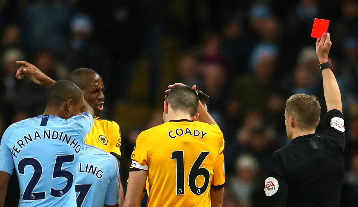Wasit memberi kartu merah kepada pemain Wolverhampton Wanderers, Willy Boly (dua kiri) usai melanggar Bernardo Silva dalam pekan ke-22 Premier League di Stadion Etihad, Manchester, Senin (14/1). (AP Photo/Dave Thompson)