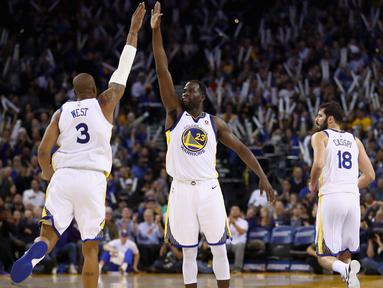 Pemain Warriors, Draymond Green #23 memberikan salam kepada rekannya David West #3 saat laga melawan Orlando Magic pada lanjutan NBA Basketball game di Oracle Arena, Oakland, (13/11/2017). Warriors menang 110-100. (Ezra Shaw/Getty Images/AFP)