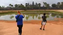 Wisatawan mengambil gambar di Kuil Angkor Wat, Provinsi Siem Reap, Kamboja, Kamis (5/3/2020). Menurut World Travel and Tourism Council, wabah virus corona (COVID-19) membuat sektor pariwisata dunia kehilangan USD 22 miliar. (TANG CHHIN Sothy/AFP)