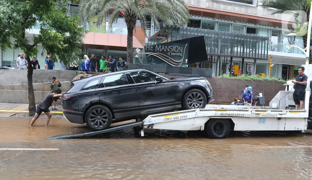 Sebuah mobil dipindahkan setelah terendam banjir di kawasan Kemang, Jakarta, Kamis (2/1/2020). Banjir yang melanda Jakarta dan sekitarnya mengakibatkan banyak kendaraan terendam air. (Liputan6.com/Herman Zakharia)