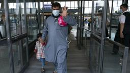 Keluarga dievakuasi dari Kabul, Afghanistan, berjalan melalui terminal sebelum naik bus setelah mereka tiba di Bandara Internasional Washington Dulles, di Chantilly, Va, Rabu (25/8/2021). (AP Photo/Jose Luis Magana)
