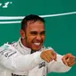 Pembalap Mercedes, Lewis Hamilton merayakan kemenangan usai merebut gelar Grand Prix F1 di Sirkuit The Americas, Minggu (25/10). Ini merupakan gelar juara dunia ketiga bagi Hamilton setelah sebelumnya diraih pada 2008 dan 2014. (REUTERS/Mike Stone)