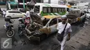 Seorang pria melintas di dekat mobil yang hangus terbakar di Pecenongan, Jakarta, Sabtu (11/2). Dalam kejadian tersebut tidak ada korban jiwa dan kerugian materiil belum bisa diperkirakan. (Liputan6.com/Immanuel Antonius)