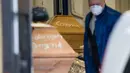 Peti mati dengan tulisan 'Corona' terlihat sebelum dikremasi di krematorium di Meissen, Jerman timur pada 13 Januari 2021. Krematorium sedang melakukan yang terbaik untuk memenuhi permintaan, menyalakan tungku kembar setiap 45 menit dan mengelola 60 kremasi sehari. (JENS SCHLUETER/AFP)