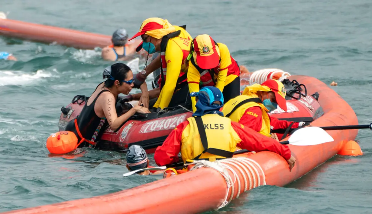 Perenang diselamatkan oleh penjaga pantai saat lomba renang tahunan di Pelabuhan Victoria, Hong Kong, Minggu (23/10/2022). (AP Photo/Anthony Kwan)