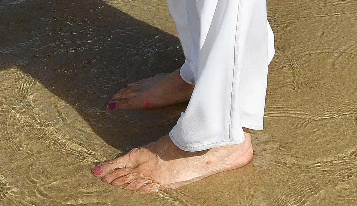 Istri Pangeran Charles, Duchess of Cornwall Camilla berjalan tanpa alas kaki di atas pasir pantai saat mengunjungi Broadbeach di Gold Coast, Kamis (5/4). Pangeran Charles dan Camilia ke Australia untuk menghadiri pembukaan Commonwealth Games. (AP Photo)