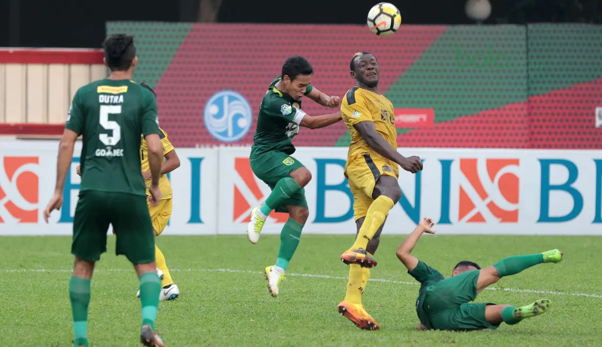 Aksi Herman Dzumafou (tengah) menghalau dari kejaran pemain Persebaya Surabaya pada laga Gojek Liga 1 bersama Bukalapak di Stadion PTIK, Jakarta, Rabu (11/7/2018). Bhayangkara FC dan Persebaya bermain imbang 3-3. (Bola.com/Nick Hanoatubun)