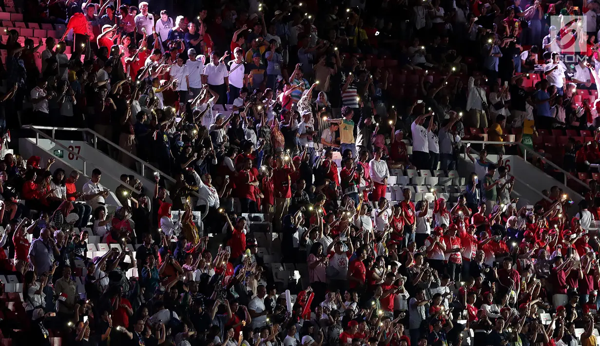 Penonton bergoyang menyalakan ponsel pintar jelang pembukaan Asian Games 2018 di Stadion Gelora Bung Karno, Senayan Jakarta, Sabtu (18/8). Gelaran Asian Games 2018 akan segera resmi dibuka hari ini pada pukul 19.00 WIB. (Liputan6.com/ Fery Pradolo)