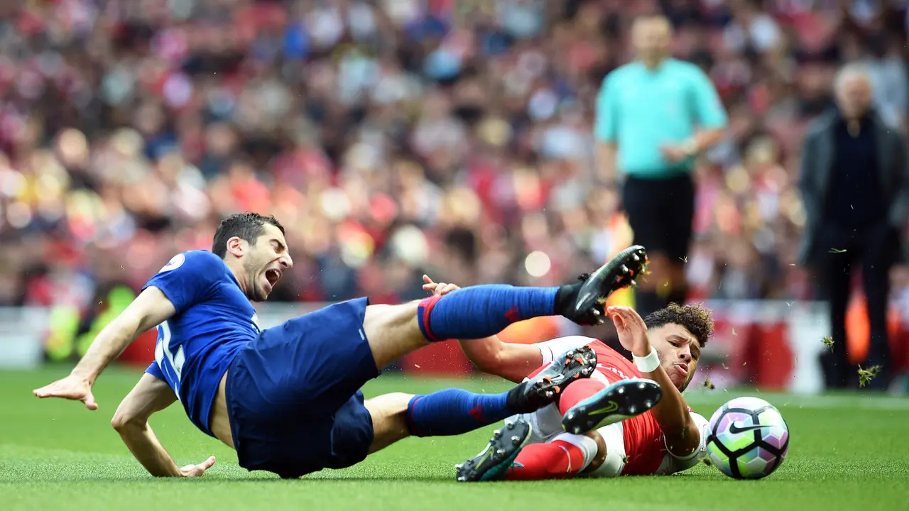 Gelandang Arsenal, Alex Oxlade-Chamberlain (kanan), menekel penggawa Manchester United (MU), Henrikh Mkhitaryan, pada laga di Emirates Stadium, Minggu (7/5/2017).