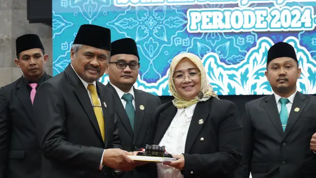 Iman legislator dari Golkar yang didapuk menerima simbolis palu pimpinan dari Ketua DPRD Garut sebelumnya Euis Ida Wartiah yang sama-sama legislator Golkar, diprediksi menjadi pimpinan DPRD Garut untuk lima tahun ke depan. (Liputan6.com/Jayadi Supriadin)