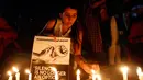 Seorang wanita India menyalakan lilin saat menggelar aksi protes kasus perkosaan di Ahmadabad, India (16/4). Selain itu dipicu juga oleh kasus penculikan serta pemerkosaan seorang gadis remaja di negara bagian utara Uttar Pradesh.(AP Photo / Ajit Solanki)