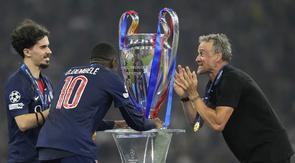 Pelatih PSG, Luis Enrique, mengangkat trofi Liga Champions 2024/2025 setelah mengalahkan Inter Milan dengan skor telak 5-0, Minggu (1/6/2025) dini hari WIB di Allianz Arena. (AP Photo/Martin Meissner)