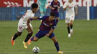 Striker Barcelona, Luis Suarez, berebut bola dengan pemain Sevilla, Jules Kounde, dalam laga lanjutan La Liga Spanyol, Sabtu (20/6/2020) dini hari WIB. Barcelona bermain imbang 0-0 atas Sevilla. (AP/Angel Fernandez)