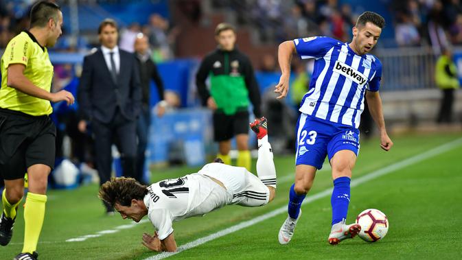 Pemain Real Madrid, Alvaro Odriozola terjatuh saat mengejar bola yang dibawa pemain Deportivo Alaves Jony Rodriguez saat bertanding pada lanjutan La Liga Spanyol di stadion Mendizorroza, Vitoria (6/10). (AP Photo/Alvaro Barrientos)