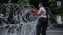 Personel kepolisian memasang kawat berduri di area gedung KPU, Jakarta, Jumat (1/3). Kawat berduri itu untuk mengantisipasi massa Forum Umat Islam (FUI) dan Gerakan Jaga Indonesia yang akan menggelar aksi di depan KPU. (Liputan6.com/Faizal Fanani)