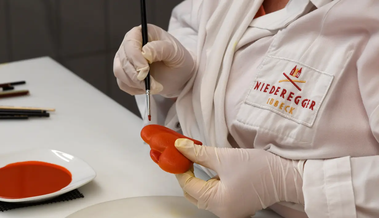 Pekerja memberi warna pada kue yang terbuat dari marzipan segar di tempat pembuatan tradisional JG Niederegger GmbH di Luebeck, Jerman (5/12). (AFP Photo/Stollarz)