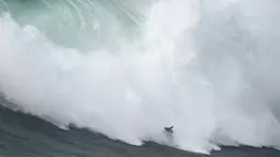 Peselancar Nic von Rupp dari Portugal mengendarai ombak selama kompetisi selancar ombak besar Nazare Tow Challenge di Praia do Norte, atau Pantai Utara, di Nazare, Portugal, Kamis, 10 Februari 2022. (AP Photo/Armando Franca)