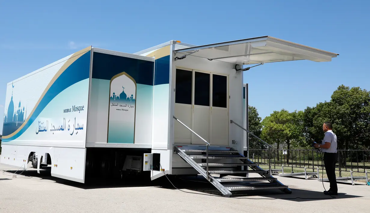 Pewarta mengambil gambar truk masjid saat peresmian di Toyota Stadium, Jepang, Senin (23/7). Truk masjid ini akan dipasang di perkampungan atlet untuk melayani kebutuhan atlet muslim selama Olimpiade 2020. (Mobile Mosque Executive Committee via AP)