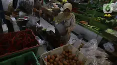 Pedagang melayani pembeli kebutuhan pokok di Pasar Santa, Jakarta, Kamis (8/12/2022). Harga bahan pokok dari sejumlah komoditas seperti cabai, bawang, daging, ayam, beras dan telur, mulai mengalami kenaikan di awal bulan Desember menjelang Natal dan Tahun Baru 2023. (Liputan6.com/Herman Zakharia)