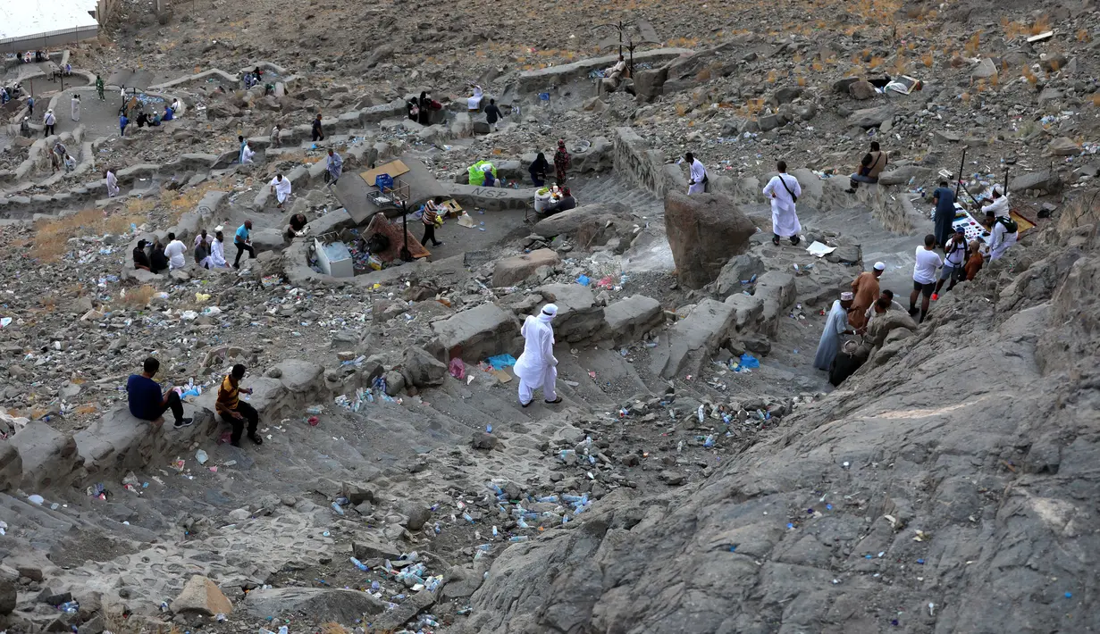 Peziarah muslim berjalan di Jabal al-Noor atau Gunung Cahaya yang menghadap ke Kota Suci Mekkah, Arab Saudi, 5 Juli 2022. Satu juta orang, termasuk 850 ribu dari luar negeri, diizinkan untuk berpartisipasi dalam haji tahun ini setelah dua tahun terakhir jumlahnya dikurangi secara drastis karena pandemi virus corona COVID-19. (Christina ASSI/AFP)