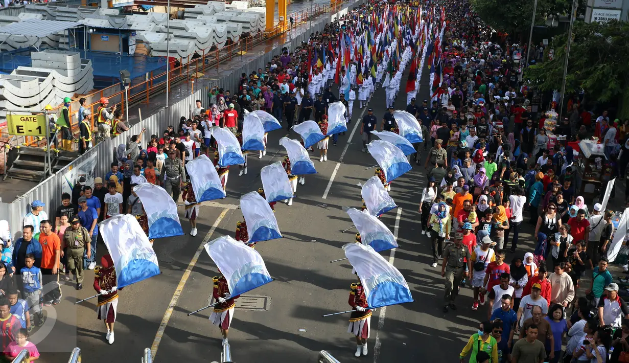 Warga yang datang ke acara CFD melihat arak-arakan bendera di kawasan Bundaran HI, Jakarta, Minggu (30/10). Parade ini merupakan rangkaian arak-arakan parade Bendera Menjelang Sidang Umum Interpol Ke-85. (Liputan6.com/Johan Tallo)
