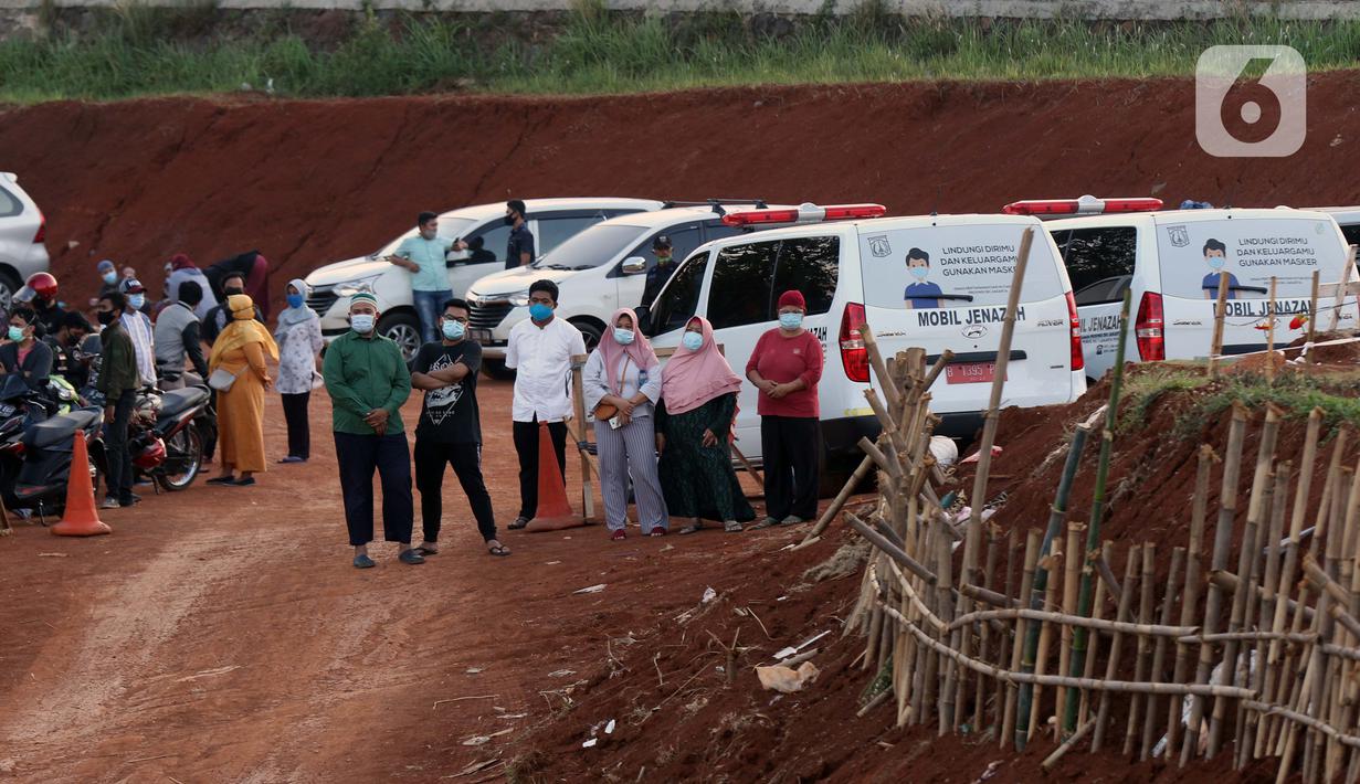 Kerabat menyaksikan proses pemakaman jenazah dengan protokol COVID-19 di TPU Pondok Ranggon, Jakarta, Sabtu (19/9/2020). Hingga Sabtu (19/9), angka positif COVID-19 di Indonesia bertambah menjadi 240.687 orang, sembuh 174.350 dan meninggal dunia 9.448. (Liputan6.com/Helmi Fithriansyah)