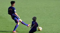Gelandang baru Barcelona, Philippe Coutinho bermain bola dengan anak-anak saat perkenalan dirinya di Nou Camp, Barcelona (8/1). Coutinho diboyong Barcelona dengan harga sebesar 400 juta euro (sekitar Rp 6,45 triliun). (AFP Photo/Lluis Gene)