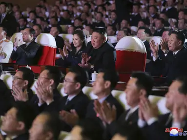 Pemimpin Korea Utara, Kim Jong-un (tengah) ditemani istrinya, Ri Sol Ju menonton pertunjukan di Pyongyang pada Selasa (16/2/2021). Istri Kim Jong-un muncul di hadapan publik untuk pertama kalinya setelah lebih dari setahun tidak terlihat. (Korean Central News Agency/Korea News Service via AP)