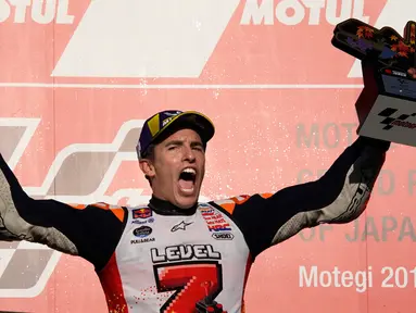 Pembalap Repsol Honda, Marc Marquez berselebrasi di atas podium setelah memenangi balapan MotoGP Jepang 2018 di Twin Ring Motegi, Minggu (21/10). Kemenangan Marquez di Jepang sekaligus membuatnya menjadi juara dunia MotoGP 2018. (AP/Shizuo Kambayashi)