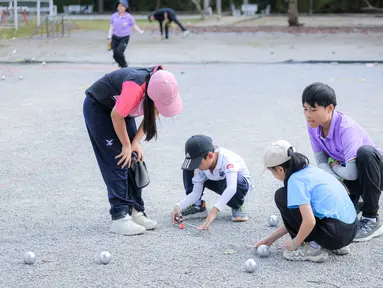 Beberapa anak memainkan olahraga Petanque di Lapangan Latih Dua Kompleks 700th Anniversary of Chiang Mai Stadium, Thailand, Kamis (11/12/2025). Petanque merupakan salah satu olahraga favorit bagi masyarakat Thailand. (Bola.com/Bagaskara Lazuardi)