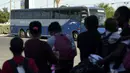 Para Migran Haiti menunggu bus setelah diproses di kamp darurat di Del Rio, Texas, Minggu (19/9/2021). Pemerintahan Presiden Joe Biden mendekati final berencana untuk mengusir ribuan migran Haiti yang tiba-tiba menyeberang ke kota perbatasan Texas dari Meksiko. (AP Photo/Eric Gay)