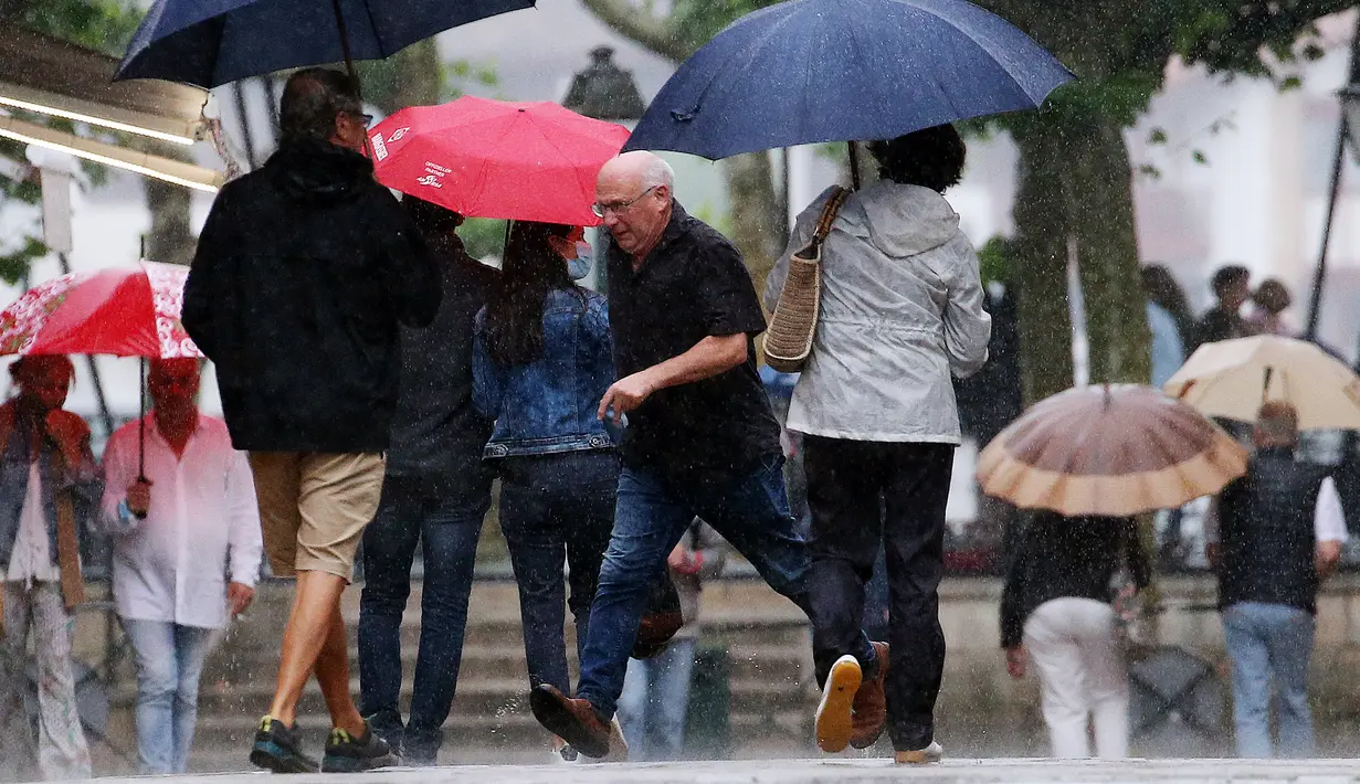 Orang-orang tanpa masker melintasi jalan di Saint Jean de Luz, Prancis, Kamis (17/6/2021). Prancis mengumumkan melonggarkan aturan pembatasan COVID-19, mencabut aturan penggunaan masker di luar ruangan dan menghentikan jam malam mulai pekan ini setelah delapan bulan terakhir. (AP Photo/Bob Edme)