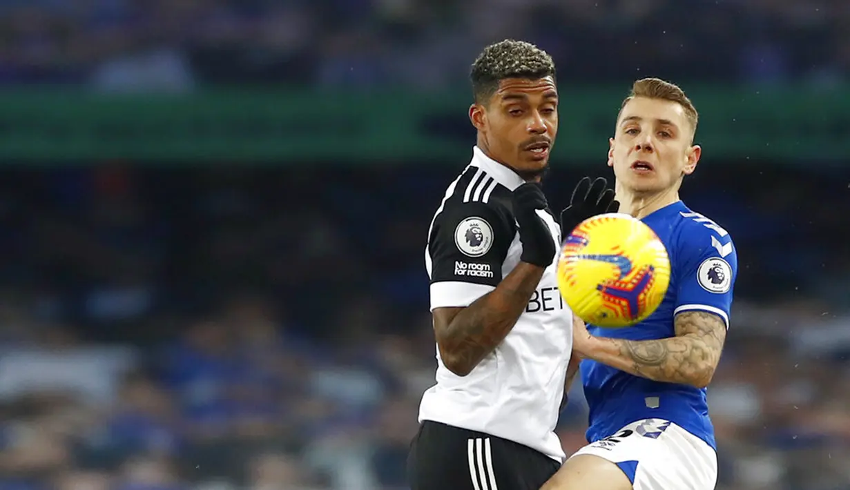 Pemain Fulham Mario Lemina (kiri) berebut bola dengan pemain Everton Lucas Digne pada pertandingan Liga Inggris di Goodison Park, Liverpool, Inggris, Minggu (14/2/2021). Everton kalah 0-2 dari Fulham. (Jason Cairnduff/Pool via AP)