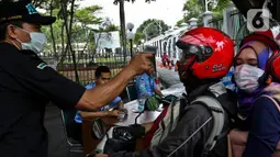 Pengendara sepeda motor menjalani pengecekan suhu tubuh saat akan masuk Kompleks Parlemen di Senayan, Jakarta, Kamis (5/3/2020). Pengecekan dilakukan sebagai tindakan preventif terkait penyebaran virus corona (COVID-19) setelah dua WNI dinyatakan positif terinfeksi. (Liputan6.com/Johan Tallo)