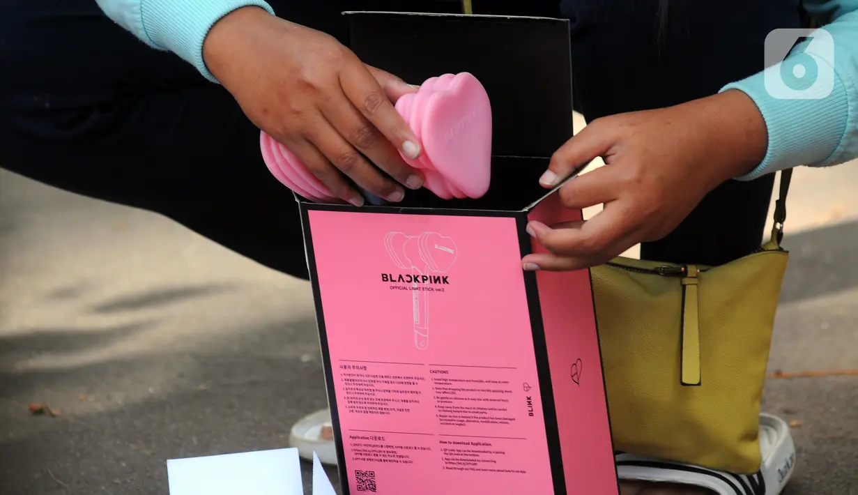 Calon penonton membuka suvenir menukarkan tiket konser Blackpink di Stadion Utama Gelora Bung Karno (SUGBK), Jakarta, Kamis (9/3/2023). Konser bertajuk Blackpink World Tour [Born Pink] Jakarta dijadwalkan akan berlangsung pada tanggal 11 dan 12 Maret 2023. (merdeka.com/Imam Buhori)