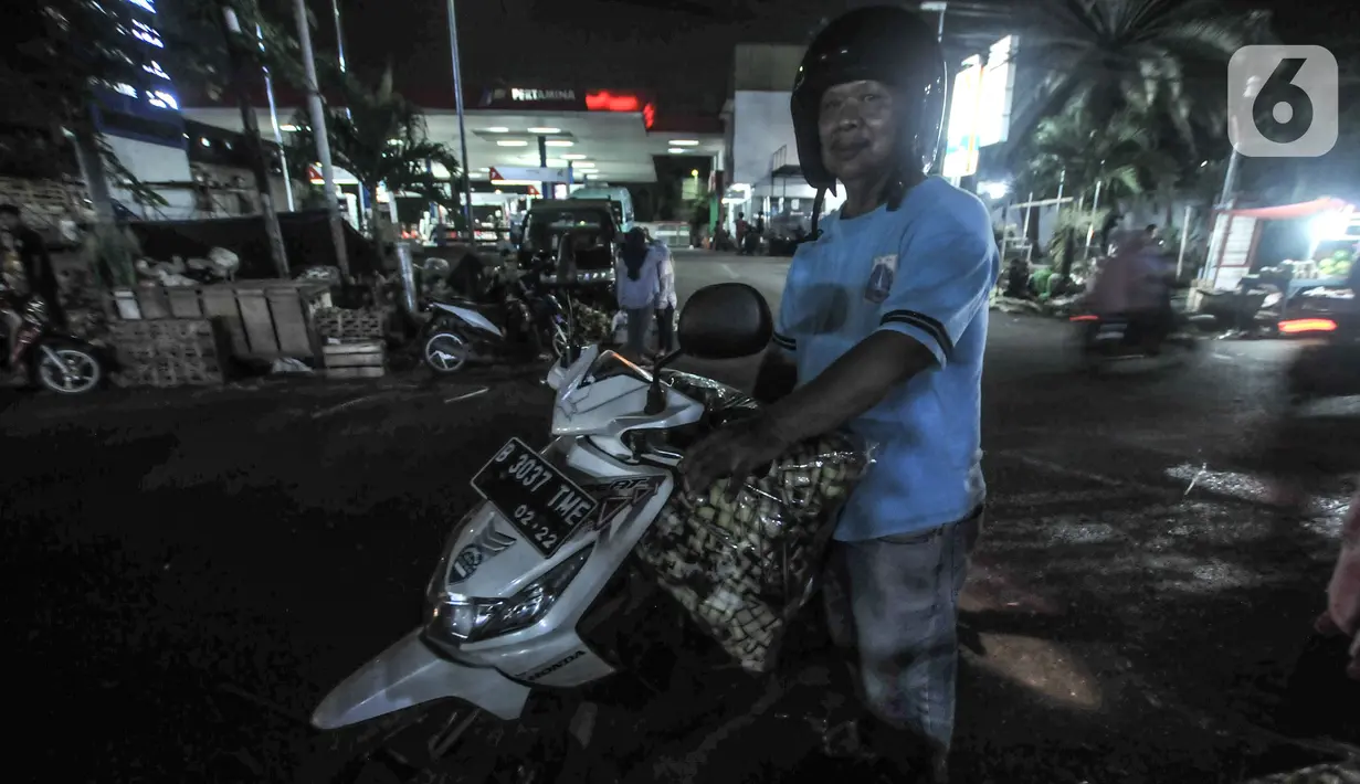 Salah satu pembeli bungkus atau tali ketupat di Pasar Klender, Jakarta Timur, Selasa (11/5/2021) malam. Biasanya empat hari menjelang Lebaran pedagang ketupat musiman tersebut mulai bermunculan menjajakan bahan baku makanan khas Idul Fitri ini. (merdeka.com/Iqbal S Nugroho