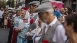 Orang-orang yang mengenakan pakaian tradisional 'chulapo' menari selama perayaan San Cayetano, santo pelindung tenaga kerja dan roti, di lingkungan Lavapies di Madrid, Spanyol, Sabtu (6/8/2022). Festival San Cayetano menandai awal dari serangkaian festival populer di Madrid. (AP Photo/Manu Fernandez)