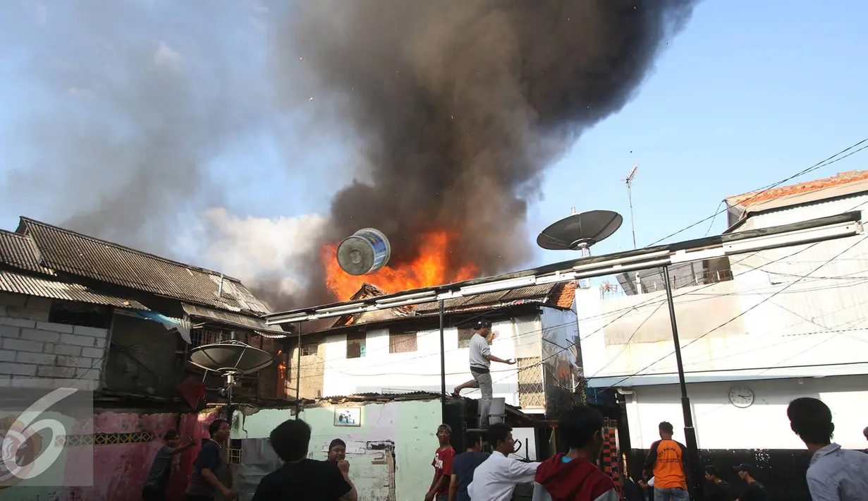 Warga berusaha memadamkan api yang membakar pemukiman penduduk di Tanah Abang, Jakarta, Senin (5/9). Sebanyak 25 unit pemadam kebakaran telah diterjunkan untuk memadamkan api yang membakar kawasan padat penduduk tersebut. (Liputan6.com/Immanuel Antonius)