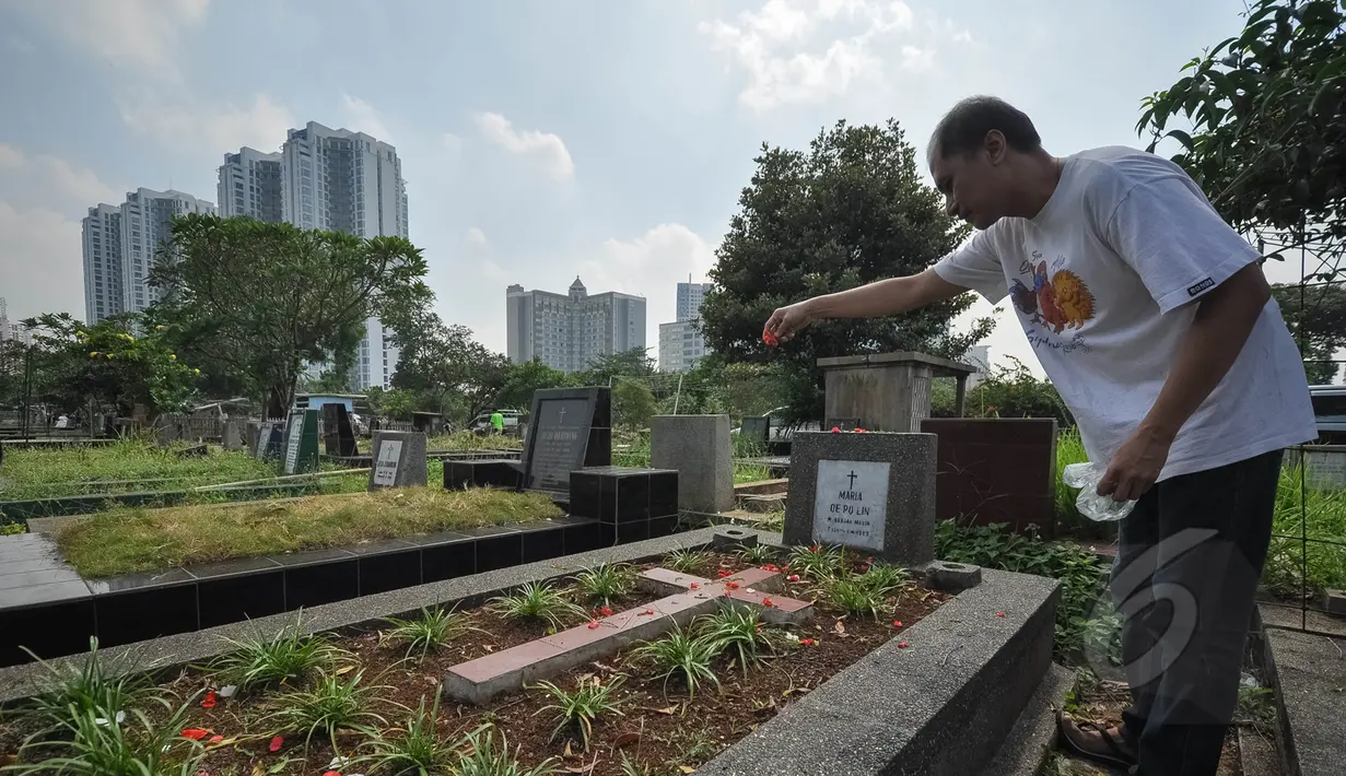 Selain merayakan Hari Kebangkitan Yesus Kristus atau Paskah di gereja-gereja, umat Kristiani juga melakukan ziarah ke makam keluarga yang telah meninggal dunia di TPU Menteng Pulo, Jakarta, Minggu (5/4/2015). (Liputan6.com/Faizal Fanani)