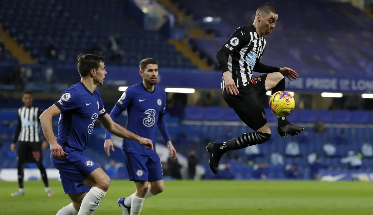 Gelandang Newcastle United, Miguel Almiron (kanan) melompat mengontrol bola di depan dua pemain Chelsea dalam laga lanjutan Liga Inggris 2020/21 pekan ke-24 di Stamford Bridges, London, Senin (15/2/2021). Newcastle kalah 0-2 dari Chelsea. (AFP/Paul Childs/Pool)