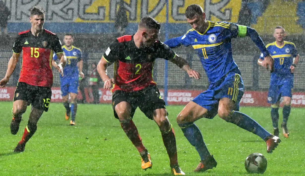 Aksi pemain Bosnia-Herzegovina, Edin Dzeko (kanan) mengecoh pemain Belgia, Toby Alderwelreld (tengah) pada kualifikasi Piala Dunia 2018 grup H di Grbavica stadium, Sarajevo, Bosnia, (7/10/2017). Belgia menang 4-3. (AFP/Elvis Barukcic)