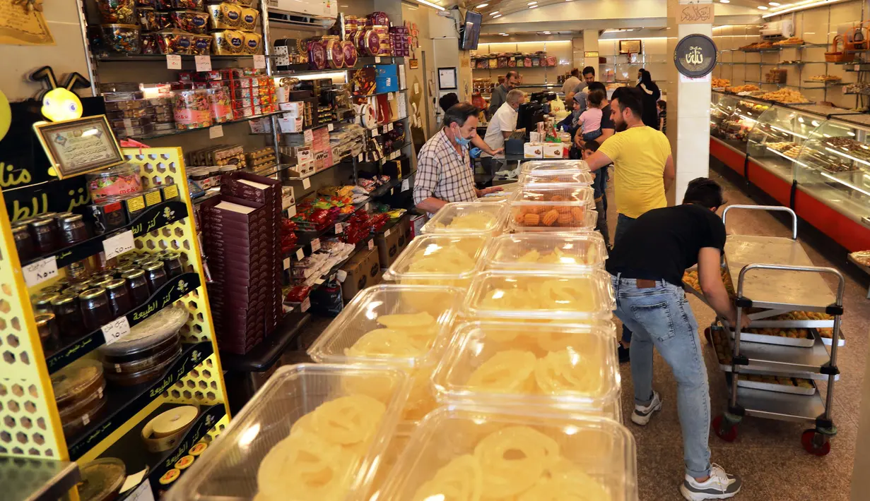 Orang-orang membeli penganan manis saat bulan suci Ramadan di sebuah toko di Baghdad, Irak, pada 3 Mei 2020. (Xinhua/Khalil Dawood)