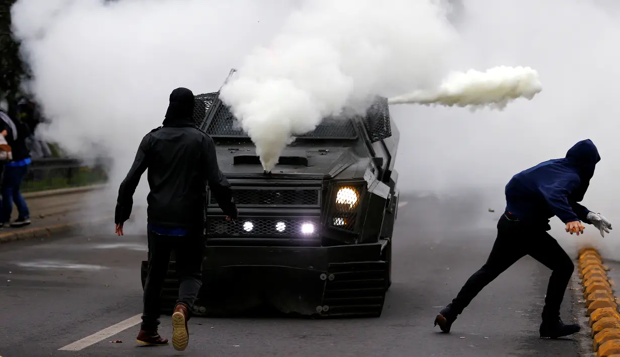Pengunjuk rasa melempari mobil petugas kepolisian anti huru hara saat bentrok menuntut perubahan sistem pendidikan di Santiago, Chili, 11 Mei 2016. (REUTERS / Ivan Alvarado)